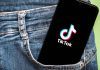 Phone with TikTok logo in jeans pocket.