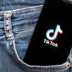 Phone with TikTok logo in jeans pocket.