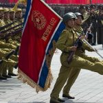 Soldiers marching with flag in military parade