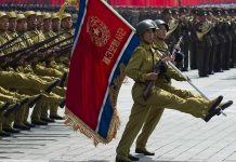 Soldiers marching with flag in military parade