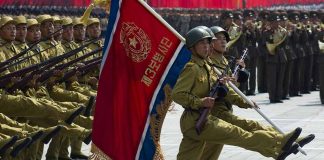 Soldiers marching with flag in military parade