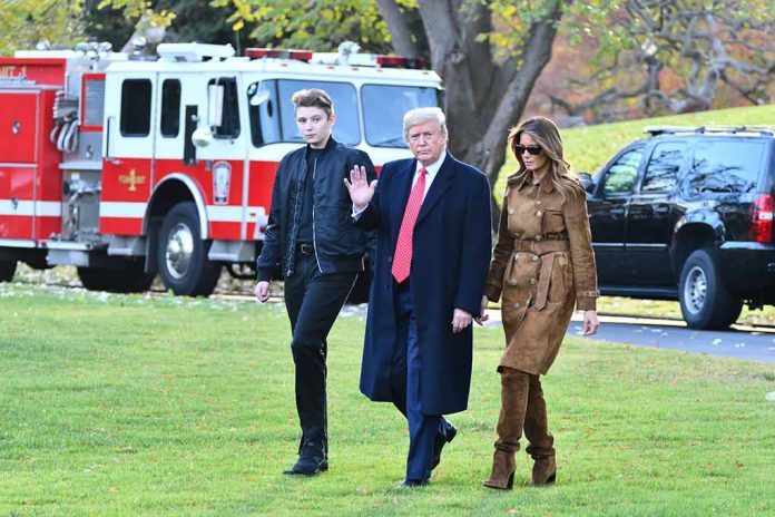 Three people walking on grass near fire truck.