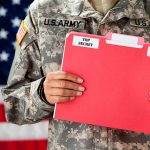 Soldier holding red top secret file folder.