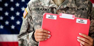 Soldier holding red top secret file folder.