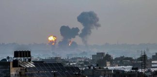 Flames and smoke billowing over a cityscape.