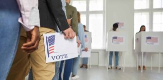 People standing in line holding voting papers