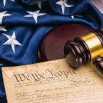 Gavel on U.S. Constitution with American flag