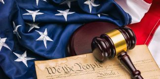 Gavel on U.S. Constitution with American flag