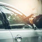 Person pointing gun at a car window