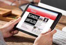 Person holding tablet displaying news headline Scandal Unfolds