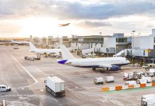 Airport with airplanes, runway, and terminal at sunset