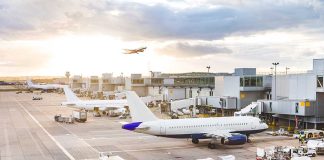 Airport with airplanes, runway, and terminal at sunset