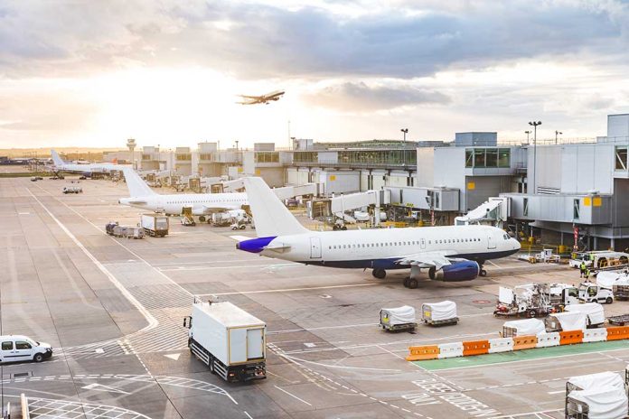 Airport with airplanes, runway, and terminal at sunset