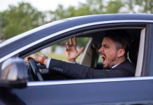 Man yelling inside a car, looking frustrated