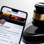 Smartphone displaying Twitter profile beside a judge’s gavel