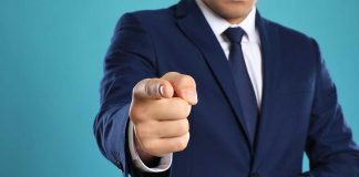 Man in a suit pointing forward