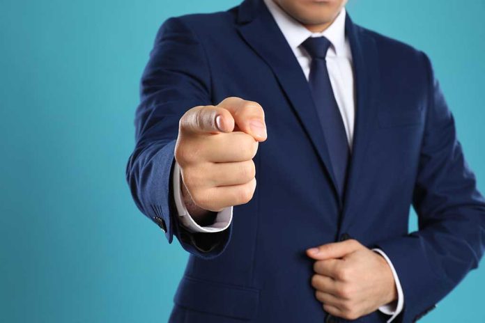 Man in a suit pointing forward