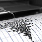 Seismograph needle recording earthquake activity on paper.