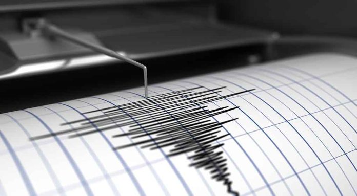 Seismograph needle recording earthquake activity on paper.