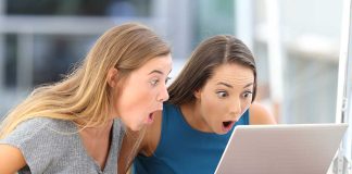 Two women surprised while looking at a laptop