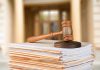 Gavel resting on stack of paperwork in courtroom