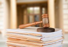 Gavel resting on stack of paperwork in courtroom