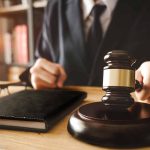 Judge holding gavel at desk