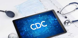 Tablet with CDC logo surrounded by medical equipment