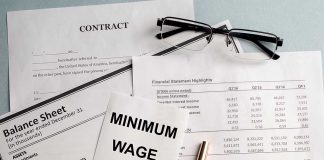 Documents and glasses on table with "Minimum Wage" paper