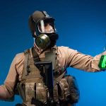 Scientist in hazmat suit holds green liquid samples