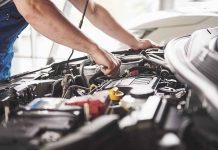 Mechanic working on an engine in a car.