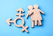 Wooden gender symbols on blue background