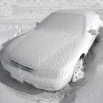 Car covered with snow in a parking lot