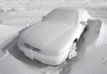 Car covered with snow in a parking lot