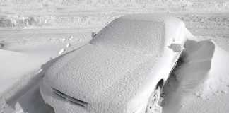 Car covered with snow in a parking lot