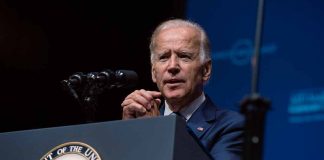 Man speaking at podium with presidential emblem visible