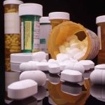 Various prescription pill bottles with scattered white tablets.