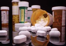 Various prescription pill bottles with scattered white tablets.