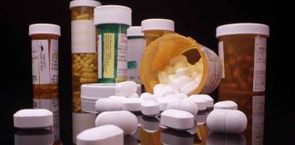 Various prescription pill bottles with scattered white tablets.