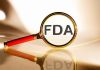 FDA under magnifying glass gold background