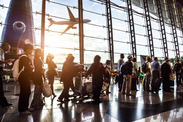 Passengers waiting at airport gate with airplane outside window.