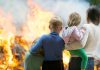 People watching large outdoor fire together