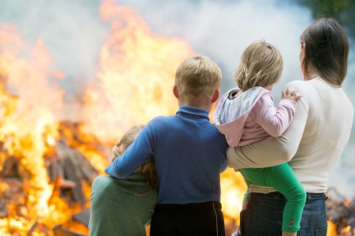 People watching large outdoor fire together