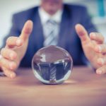 Man in suit reaching for crystal ball