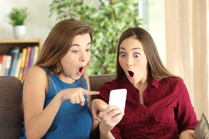 Two women look surprised at a phone.