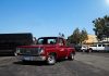 Red vintage truck parked in sunny urban setting