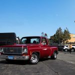 Red vintage truck parked in sunny urban setting