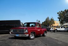 Red vintage truck parked in sunny urban setting