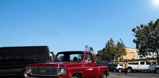 Red vintage truck parked in sunny urban setting