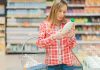 Woman reading label in grocery store aisle